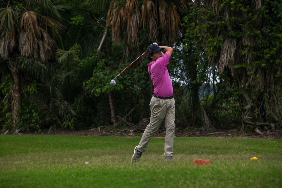 young golfer swinging golf club Thailand