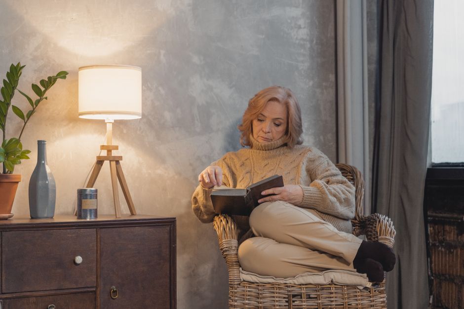 adult woman reading book relaxing living room cozy interior