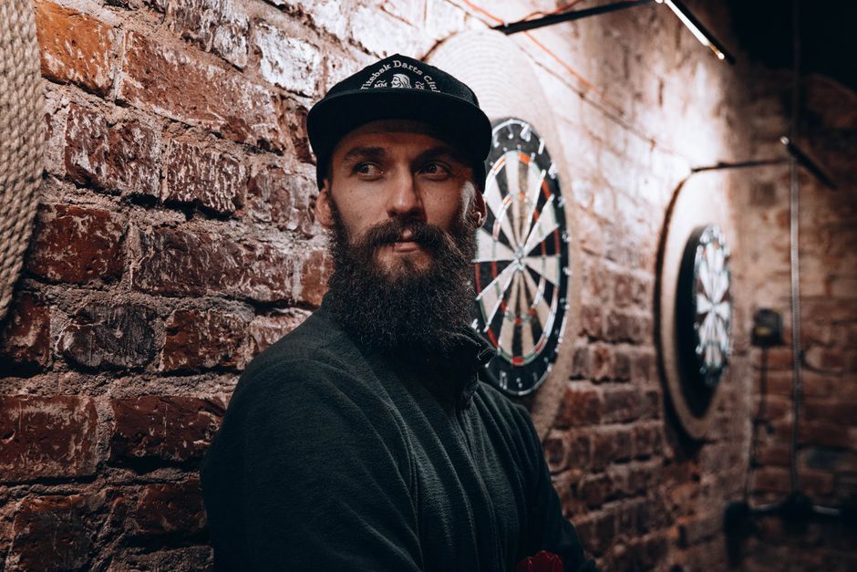 professional darts player throwing at dartboard arena