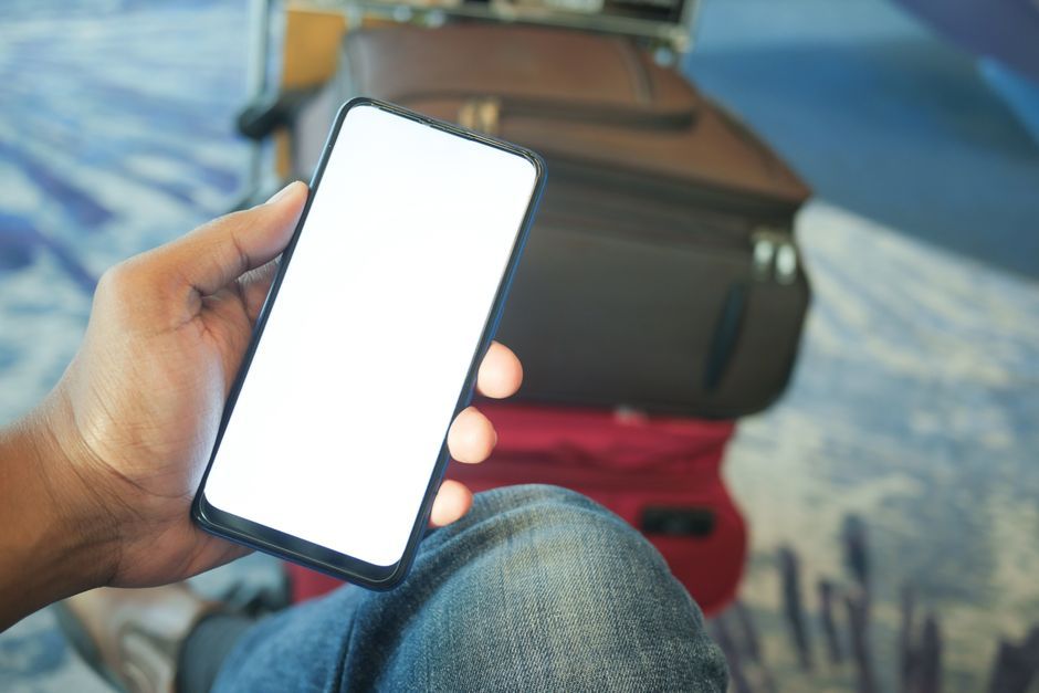 traveler checking smartphone airport terminal