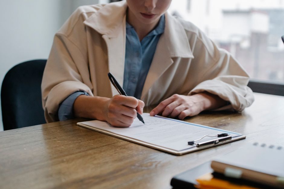 job applicant writing laptop resume desk workspace
