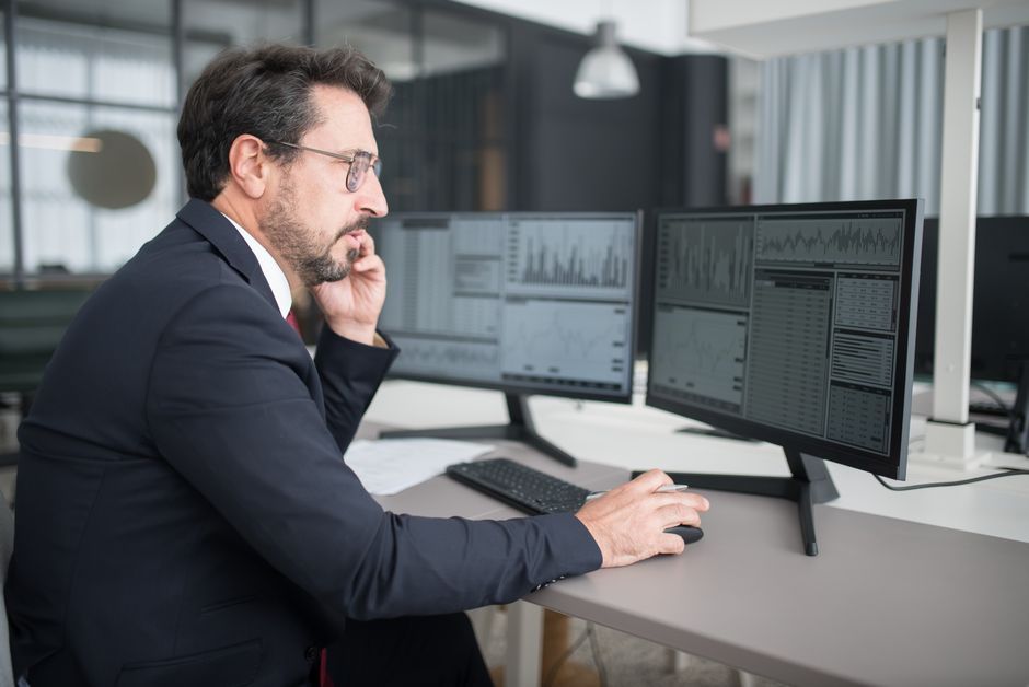 business professional analyzing data screen office desk