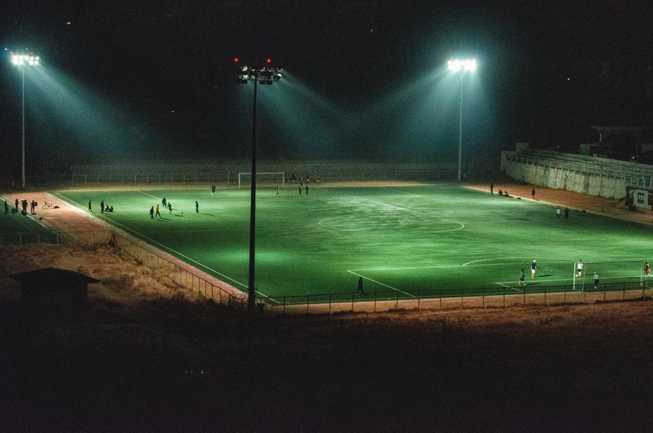 soccer stadium floodlights night match crowd no team crest