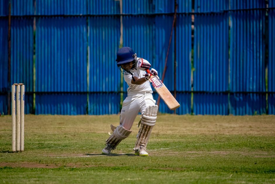 cricket player batting stadium match