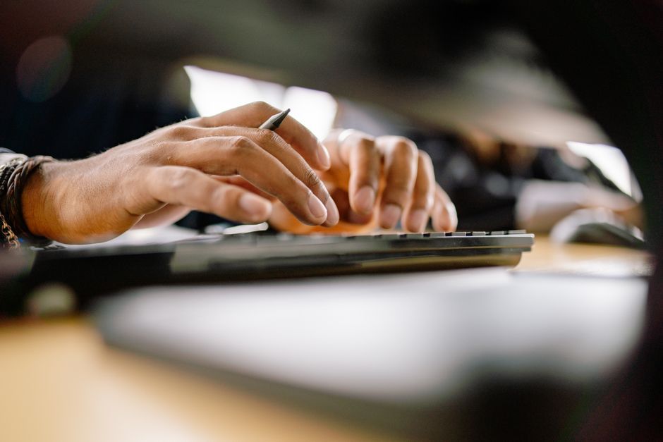 person typing on computer keyboard close up