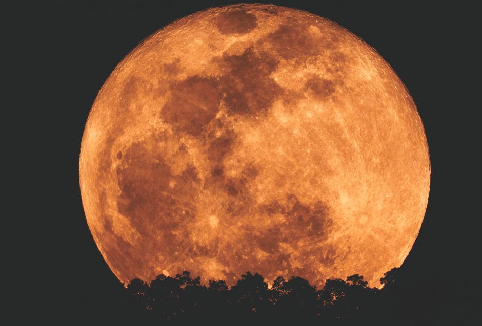 full moon rising horizon orange glow