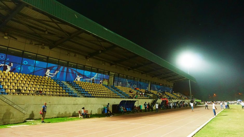 athlete running track sports stadium crowd