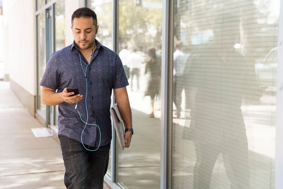 person walking outdoors with smartphone