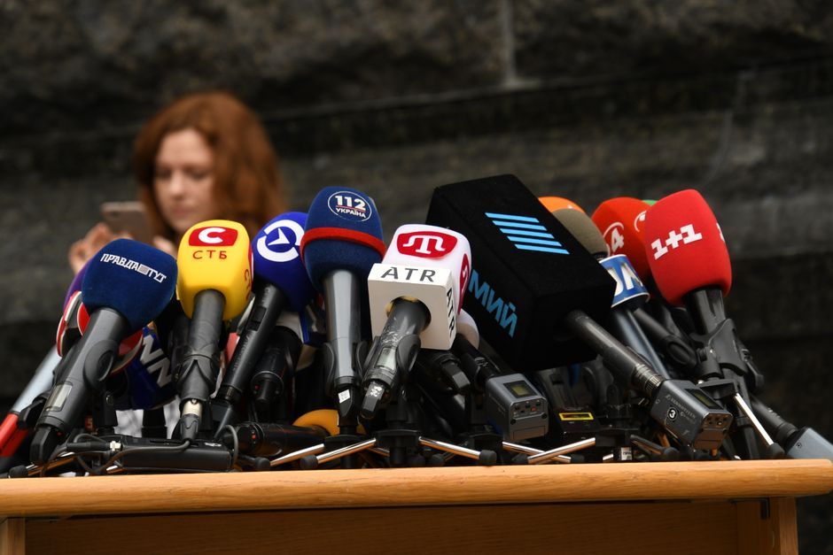 politician speaking to reporters microphone