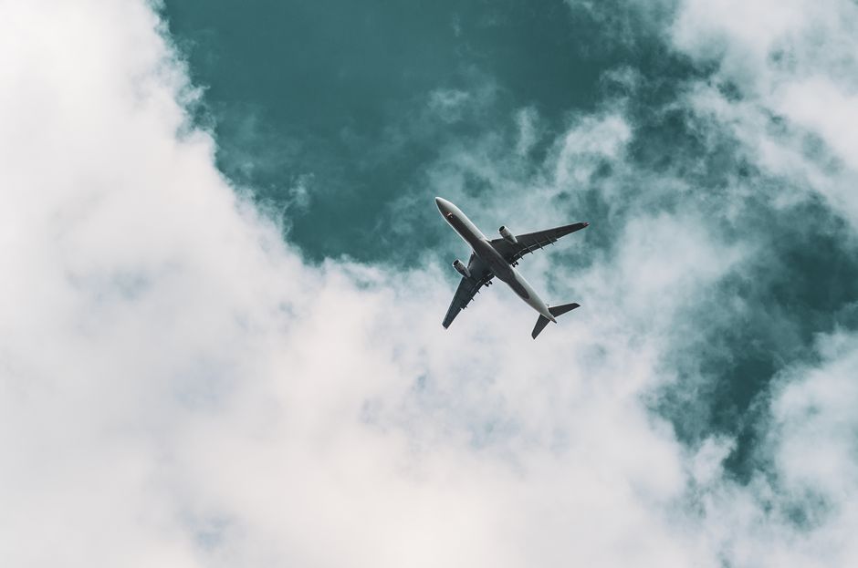 commercial airliner flying high altitude clouds sky