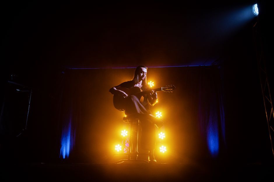 acoustic guitar music performance stage warm lighting