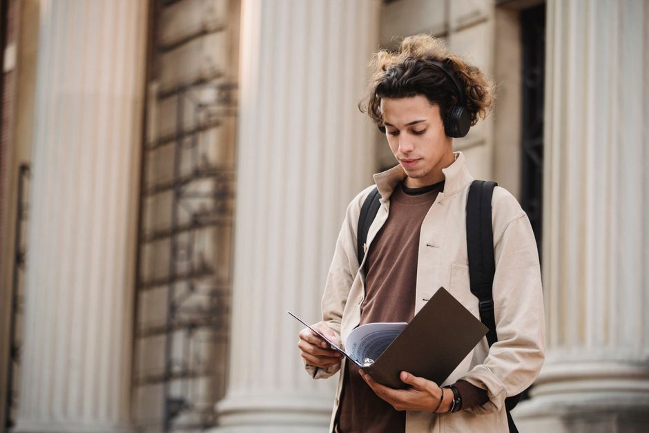 student notebook studying university campus building exterior