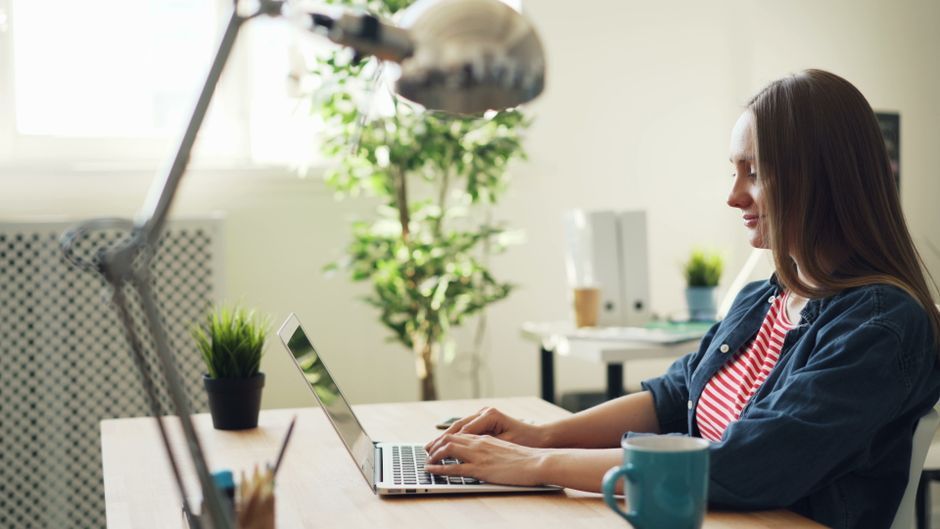 UK woman working laptop remote workspace