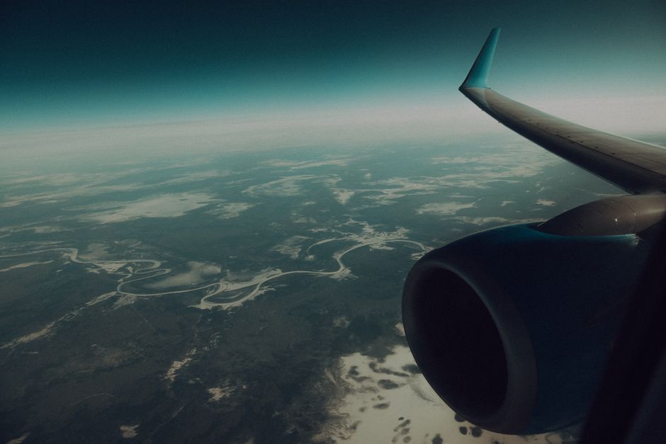 airplane wing view through window cloudy sky